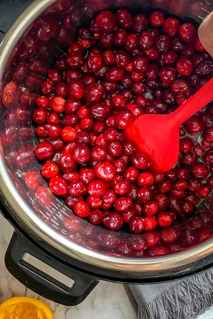 Stir cranberries in the Instant Pot for making cranberry butter