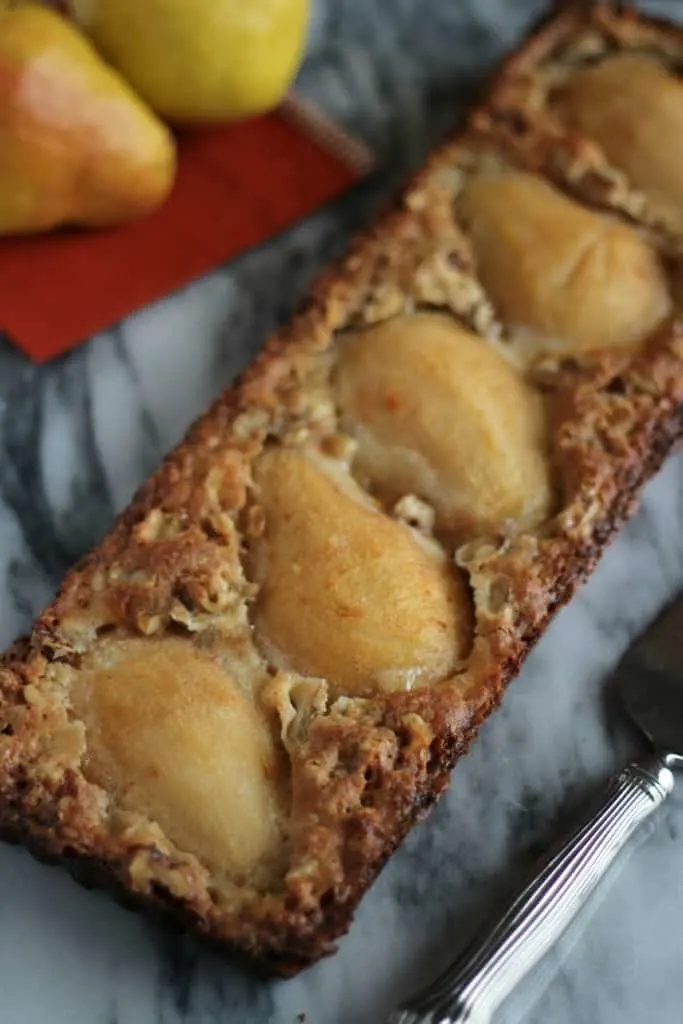 pear and walnut tart GF on marble board with cake server