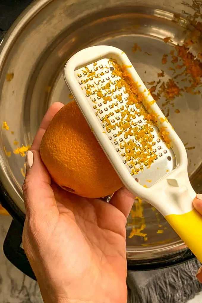 hand holding citrus tool to Zest oranges into Instant Pot