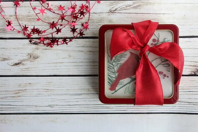 Red ribbon around a square cookie tin