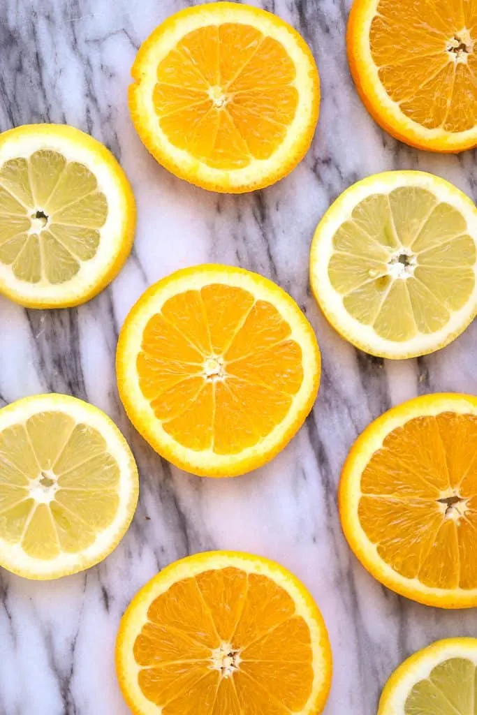 slices or oranges and lemons on marble surface