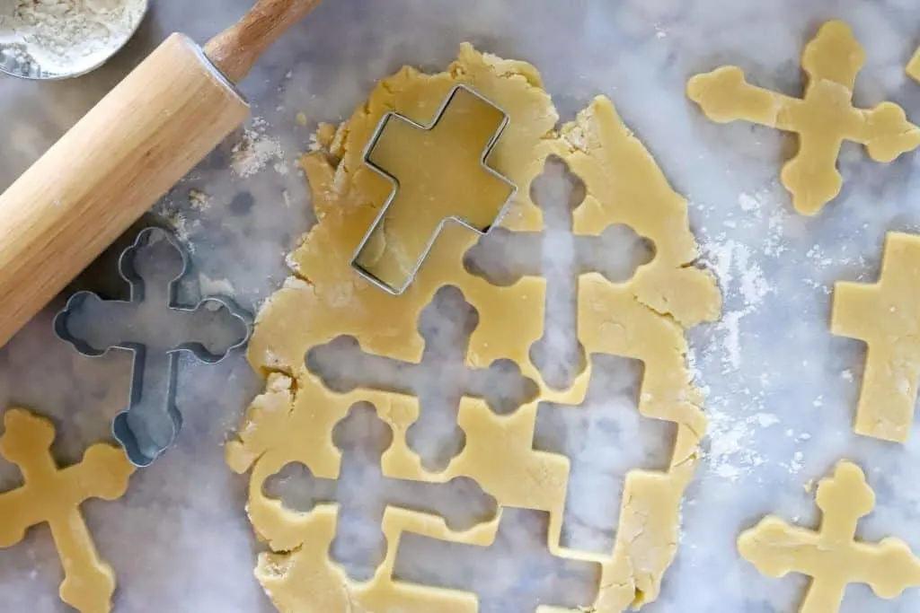 Sugar cookie dough with cross cookie cutters and rolling pin