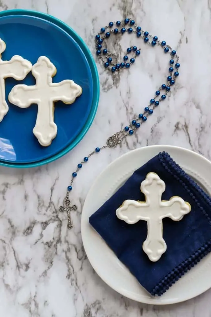 Cross cookies for a first communion celebration on white and blue plates