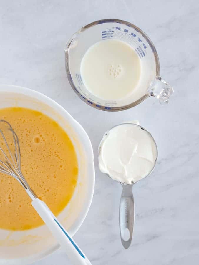 wet ingredients for quick bread of eggs, sour cream and milk