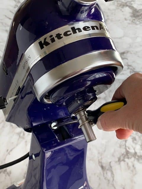 Artisan KitchenAid mixer with adjustment screw exposed and screwdriver 