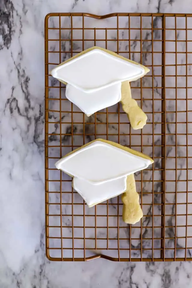 Step 4 decorating two cookies shaped like graduation caps