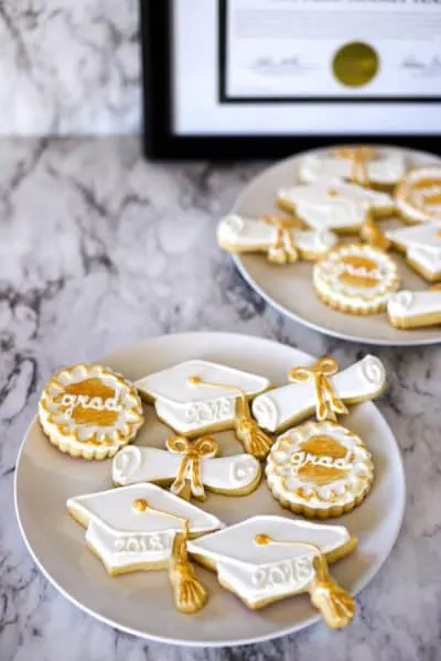 two dozen decorated sugar cookies with royal icing for graduation cookies