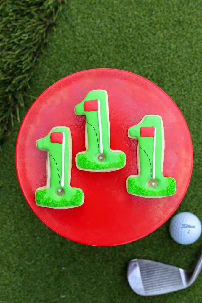 three golf cookies on a red plate