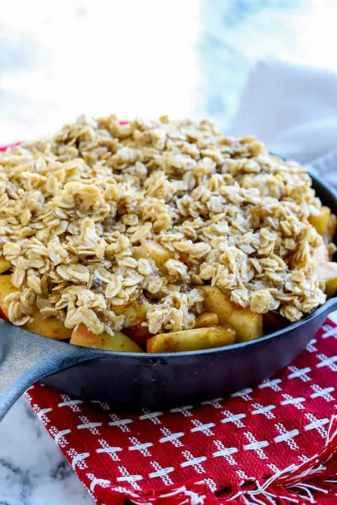 Gluten free easy apple crisp ingredients in a cast iron skillet before baking