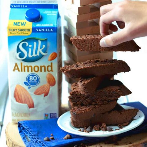 Stack of vegan chocolate biscotti with carton of Silk almondmilk