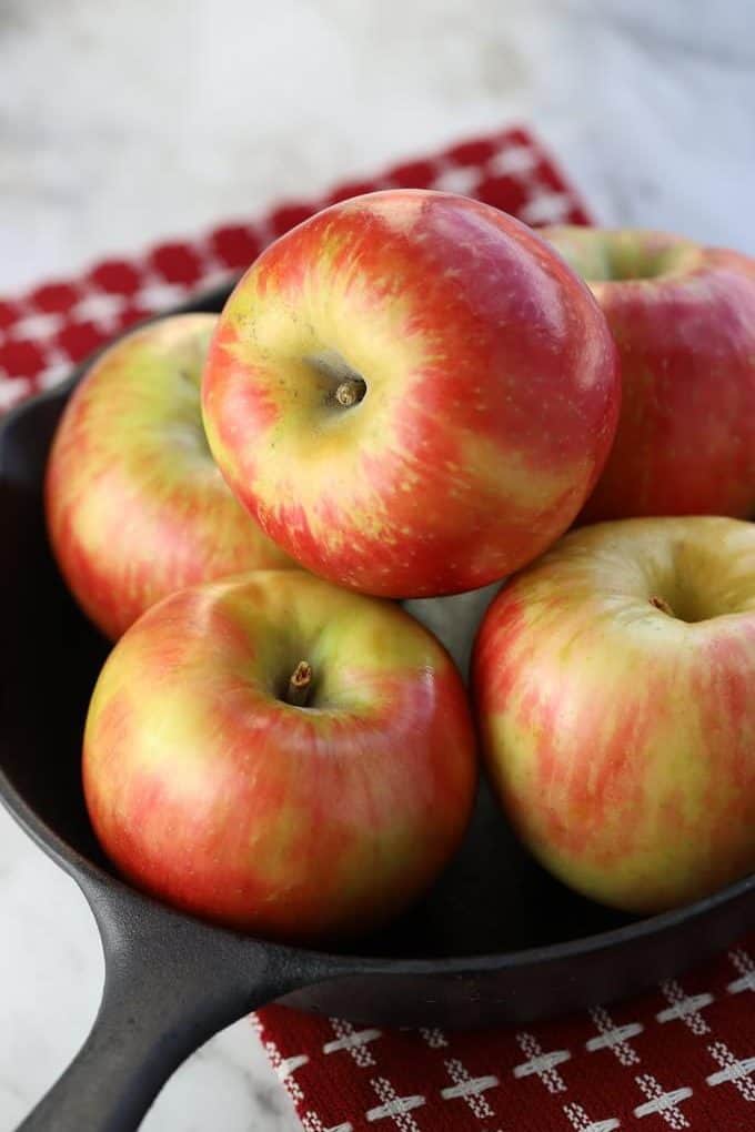 Honeycrisp apples in a cast iron pan sitting on a red and white napkin