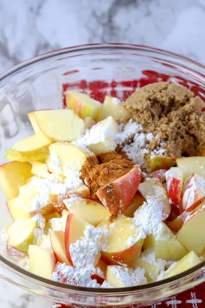 Ingredients for apple crisp filling in a glass bowl on countertop