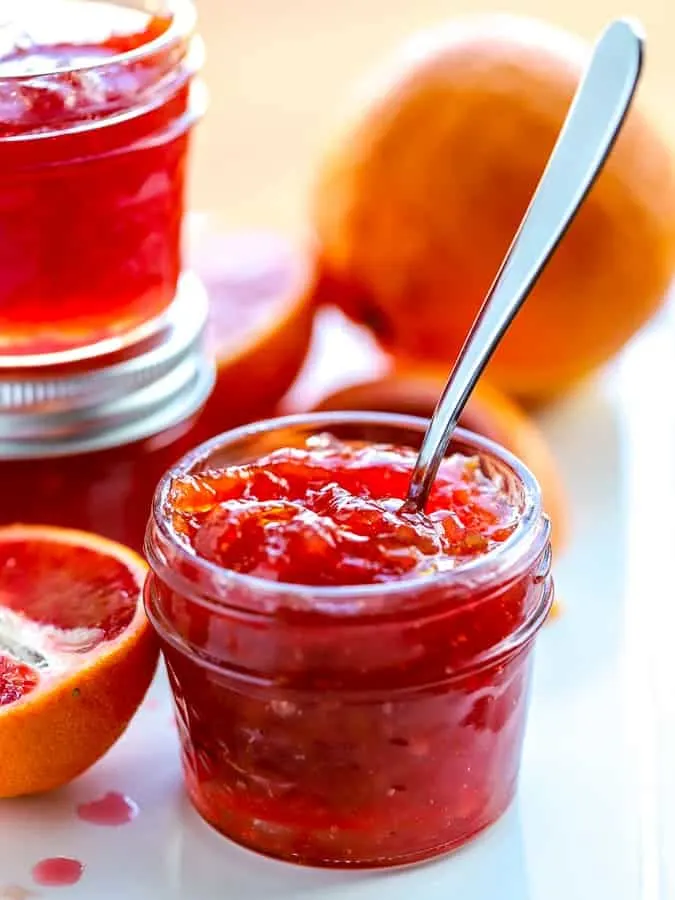 blood orange marmalade in a mason jar on a white platter