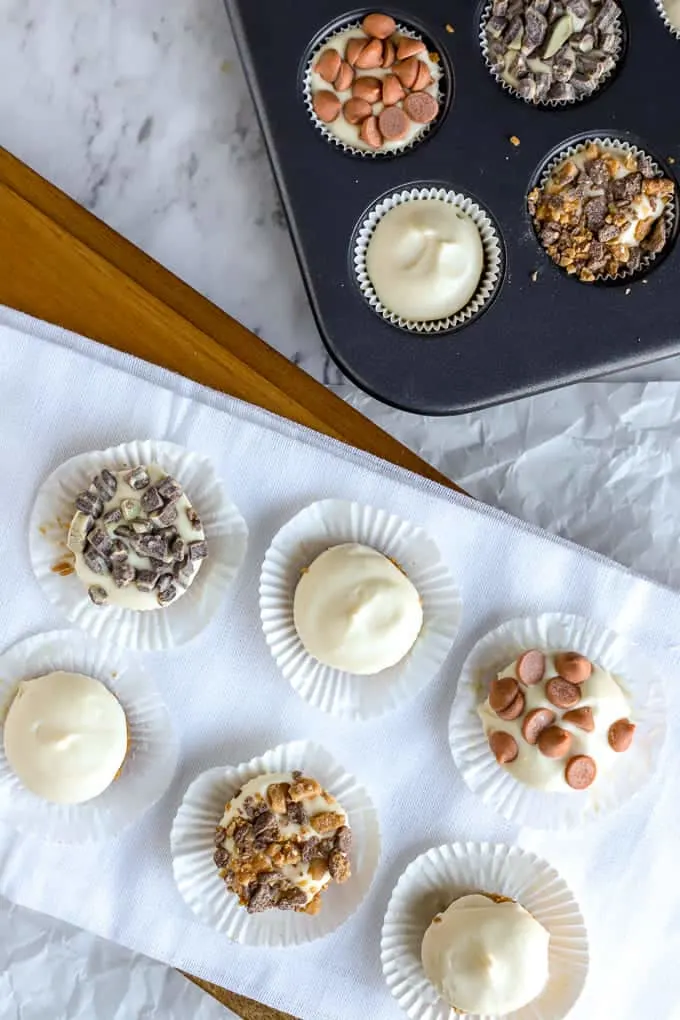 overhead photo of no bake cheesecakes in muffin tin and on white tray
