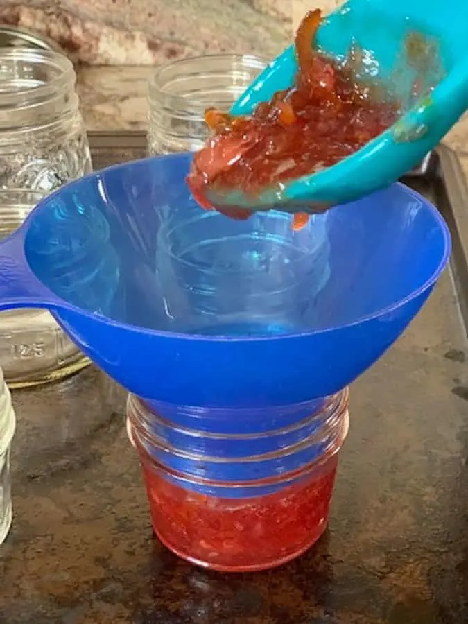 Use a silicone spoon and a jam funnel to ladle the jam into mason jars