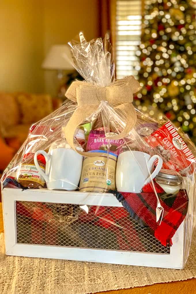 Hot chocolate gift basket wrapped in cellophane and tied with burlap bow