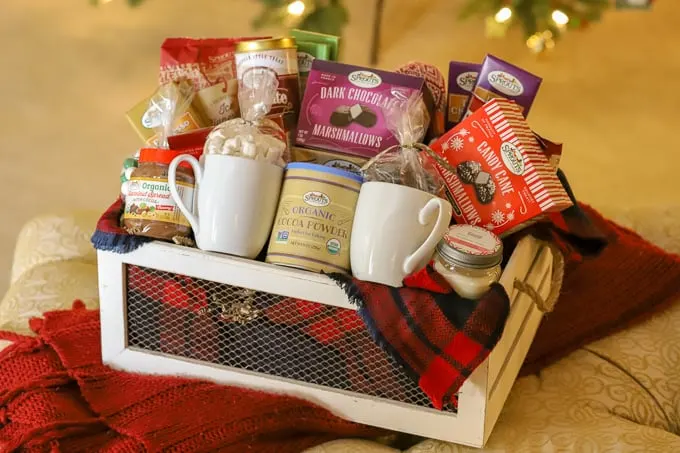 white container filled with chocolate and food items for a homemade gift basket