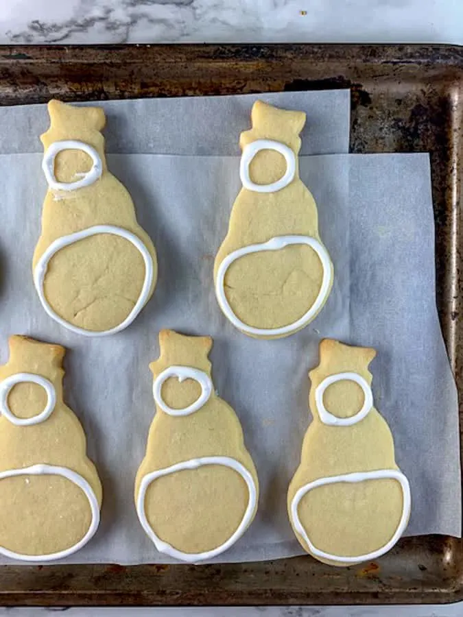 two white circles iced on snowman cookies