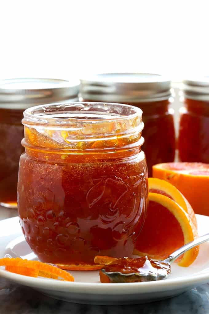 Jars of cara cara orange marmalade by a window
