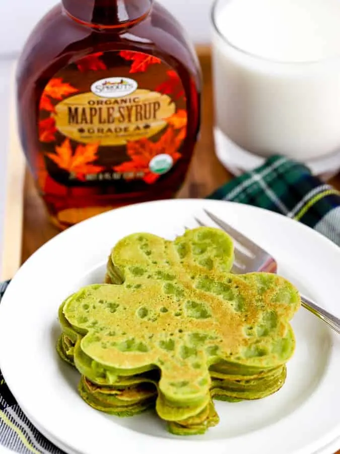 green shamrock shaped pancakes with maple syrup