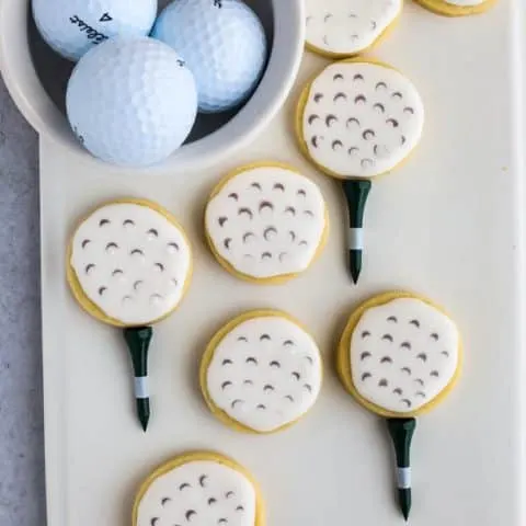 How to make golf ball cookies finished sugar cookies on a white plate with bowl of golf balls