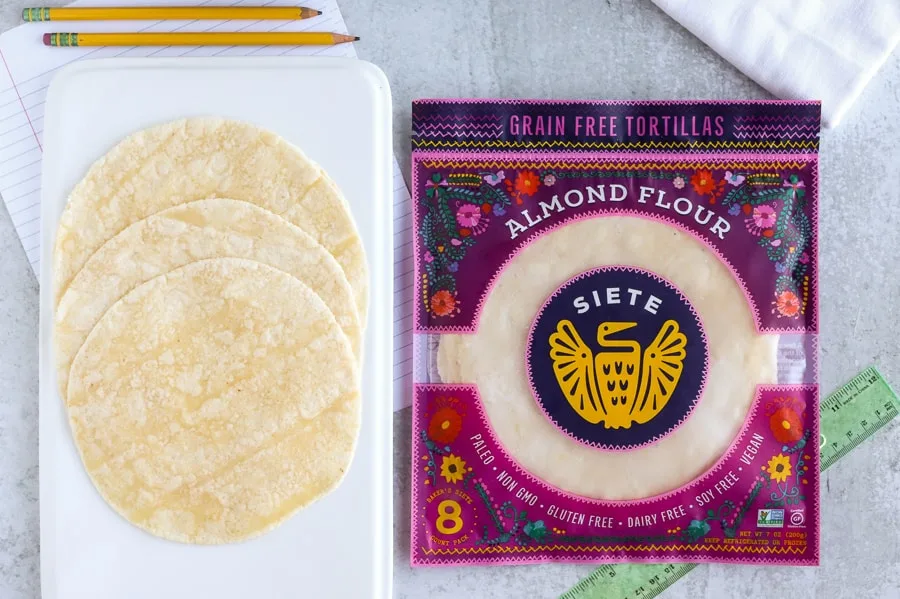 Siete Family foods almond flour tortillas on a white plate next to package