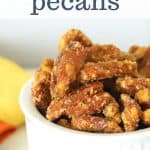 Close up photo of candied pecans with maple syrup in a white bowl for Pinterest sharing