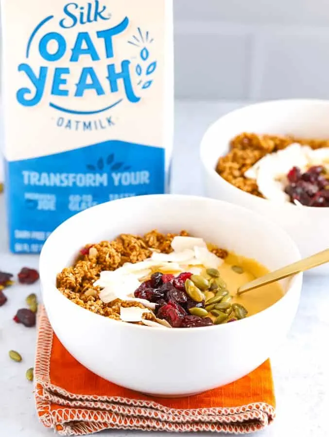 Two bowls of pumpkin smoothie with Oat Yeah oatmilk in background