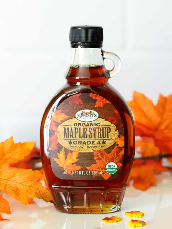 a bottle of Sprouts Farmers Market organic maple syrup with orange leaves on countertop