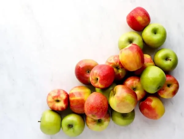 Apples in a pile of honeycrisp, granny smith and pink lady apples