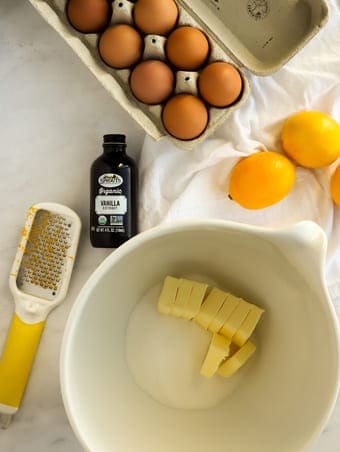 butter, vanilla, eggs and lemons on a marble board