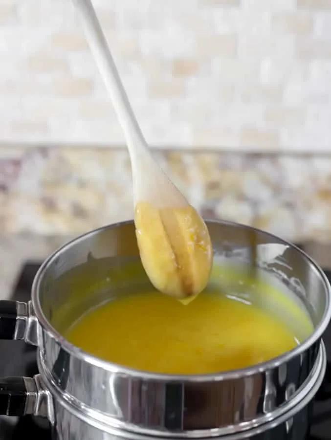 Wooden spoon with curd and double boiler