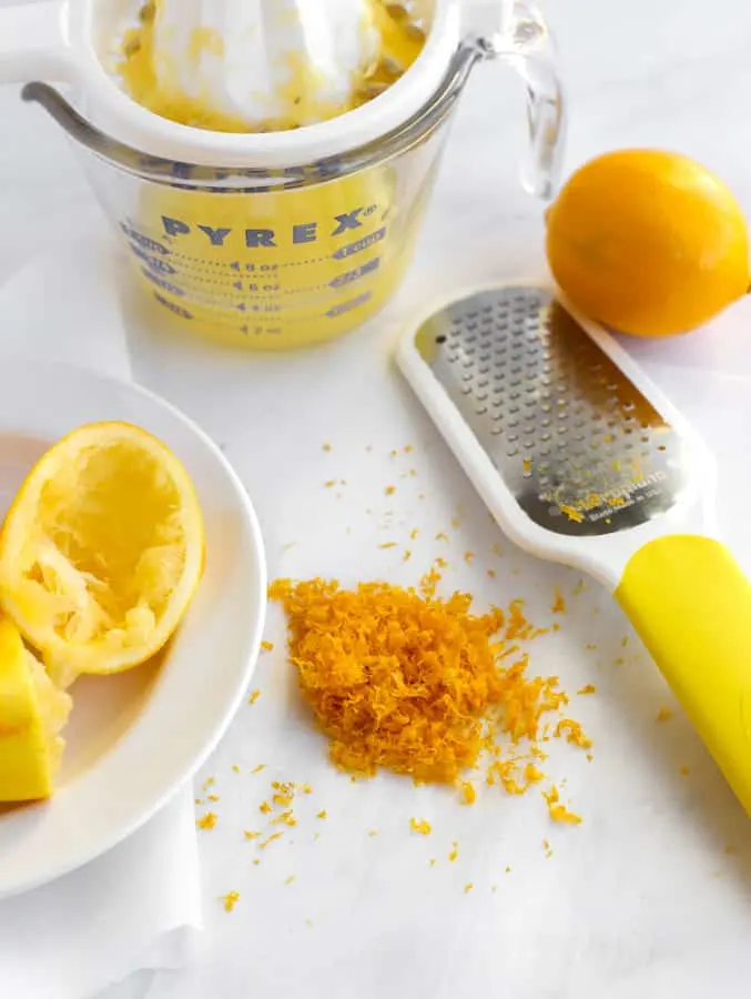 Citrus zester, squeezed meyer lemons and zest on marble board