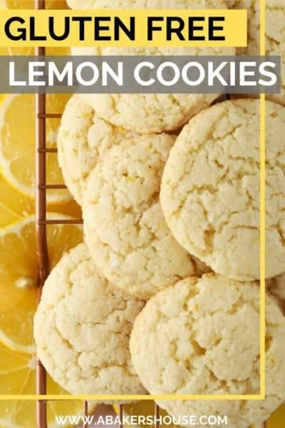 gluten free lemon cookies piled on baking wire rack with lemon slices underneath