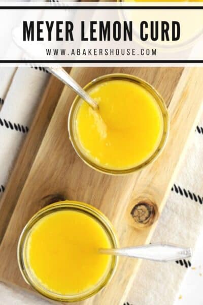 Overhead photo of jars of lemon curd on wooden board and white and black towel