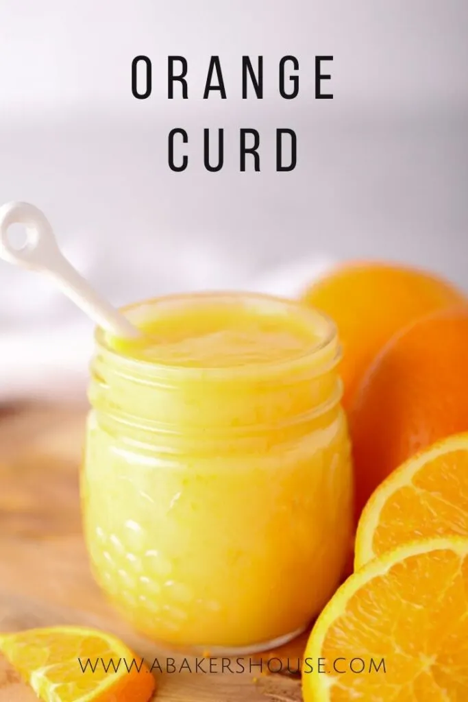 orange curd with white spoon and sliced oranges on cutting board