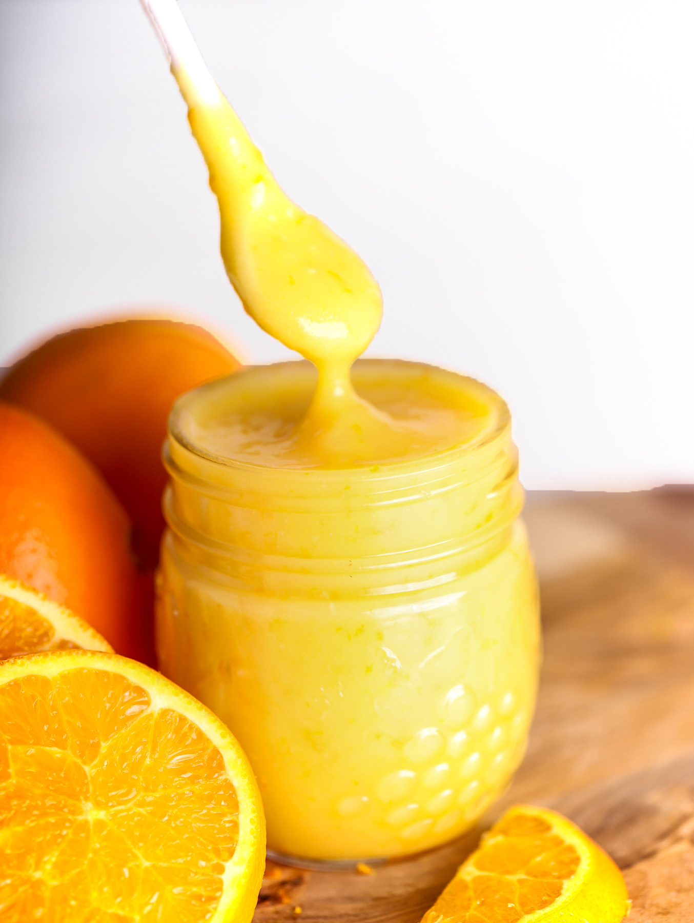 spoon dipping into jar of orange curd