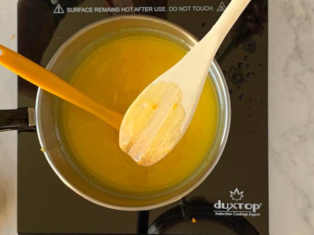 Wooden spoon coated with orange curd