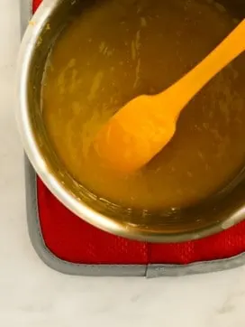 yellow spatula in saucepan of vegan lemon curd