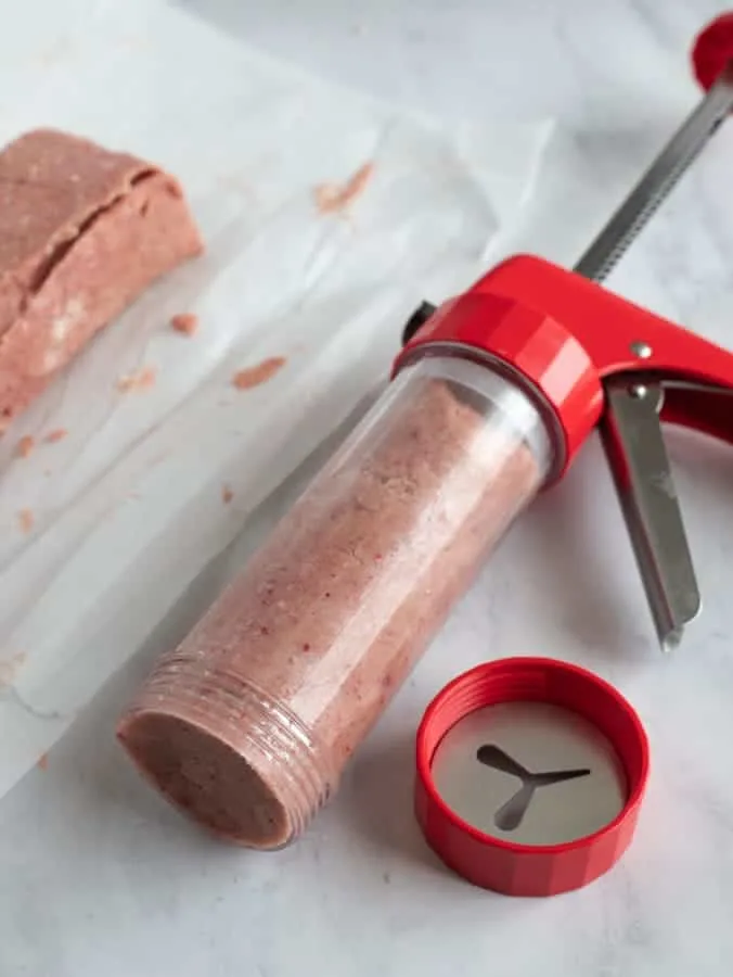 Spritz cookie press with pink cookie dough