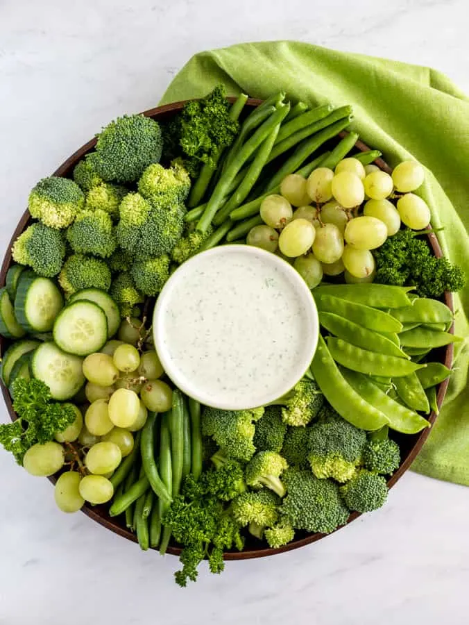 cucumber and feta dip with green napkin and fruits and veggies