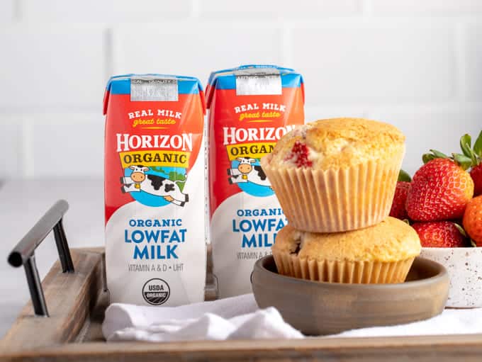 stack of two strawberry muffins with two cartons of Horizon Organic milk on a wooden tray