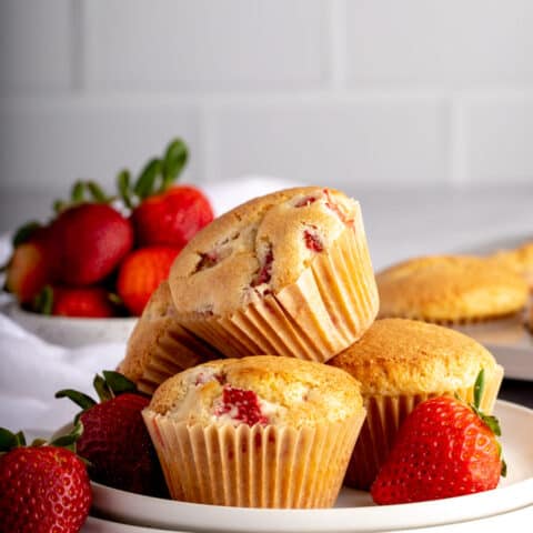 group of 4 strawberry muffins on white plates