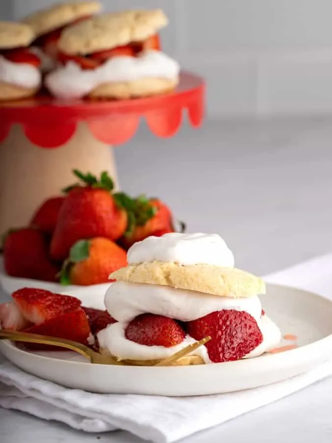 strawberry shortcake on white pottery plate with white napkin