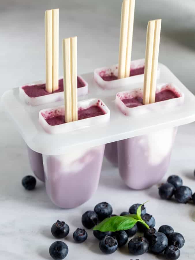 Chopsticks used as popsicle handles with blueberry creamsicles in popsicle molds