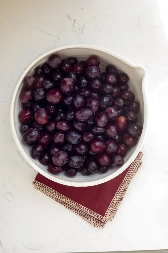 Bowl full of Gum Drop Grapes on a white surface