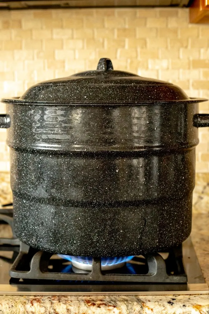 Boiling water canner on a stovetop with tile backsplash