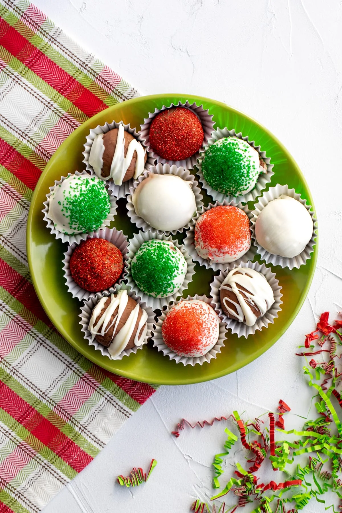 plate of Christmas chocolate truffles in green, red, and white on a green plate