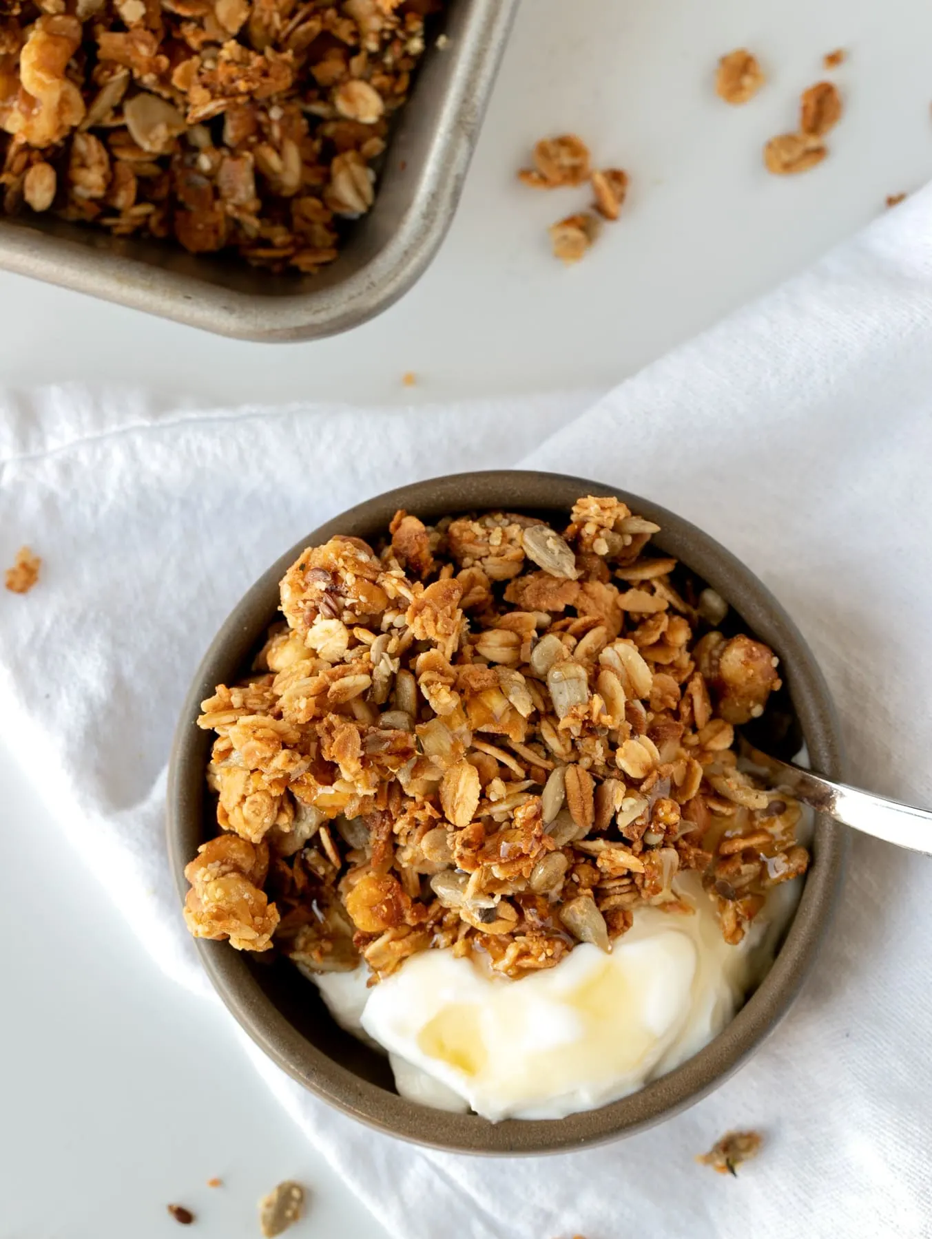 bowl of yogurt and honey granola on white surface