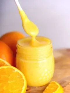 spoon dipping into mason jar filled with orange curd